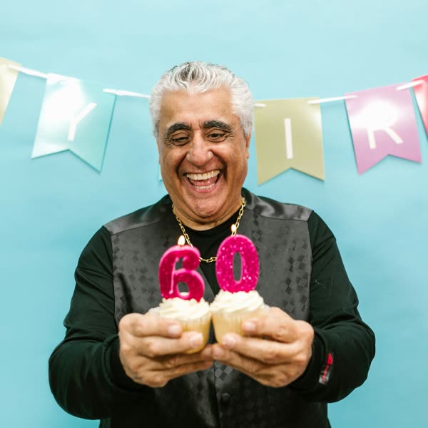 Un homme souffle ses bougies d'anniversaire, tout sourire